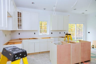 Custom-kitchen-cabinets-in-various-stages-of-installation-base-for-island-in-center-Installation-of-kitchen-cabinets-768x512