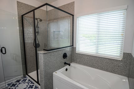 Peppered Onyx shower walls and tub surround with bold black fixtures